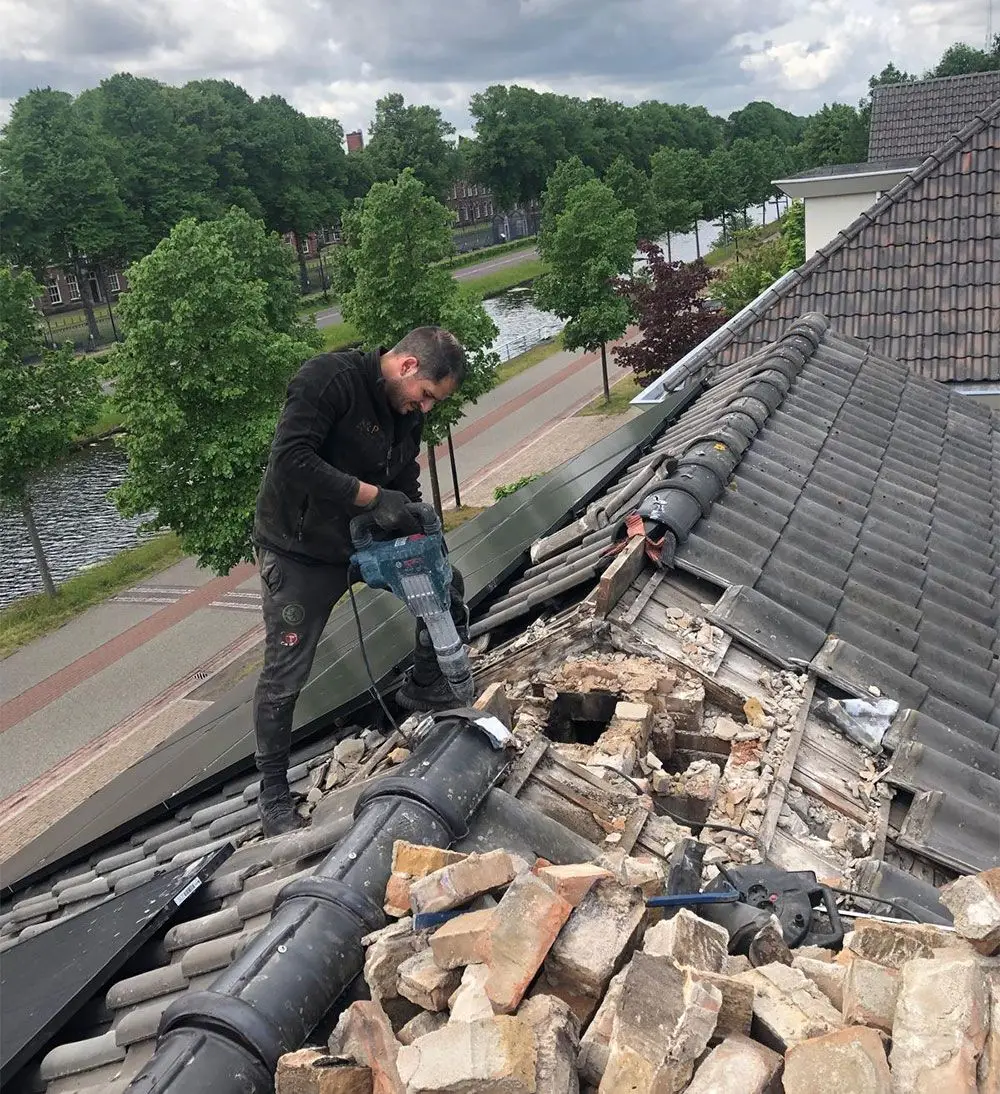 Dakdekker verwijdert de oude nok van een pannendak